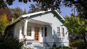Une maison de plain-pied avec un porche, une porte d’entrée et un petit jardin devant.