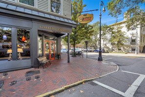 A storefront with a sign for Gallery Espresso, featuring a bench outside, a brick sidewalk, and a street view.