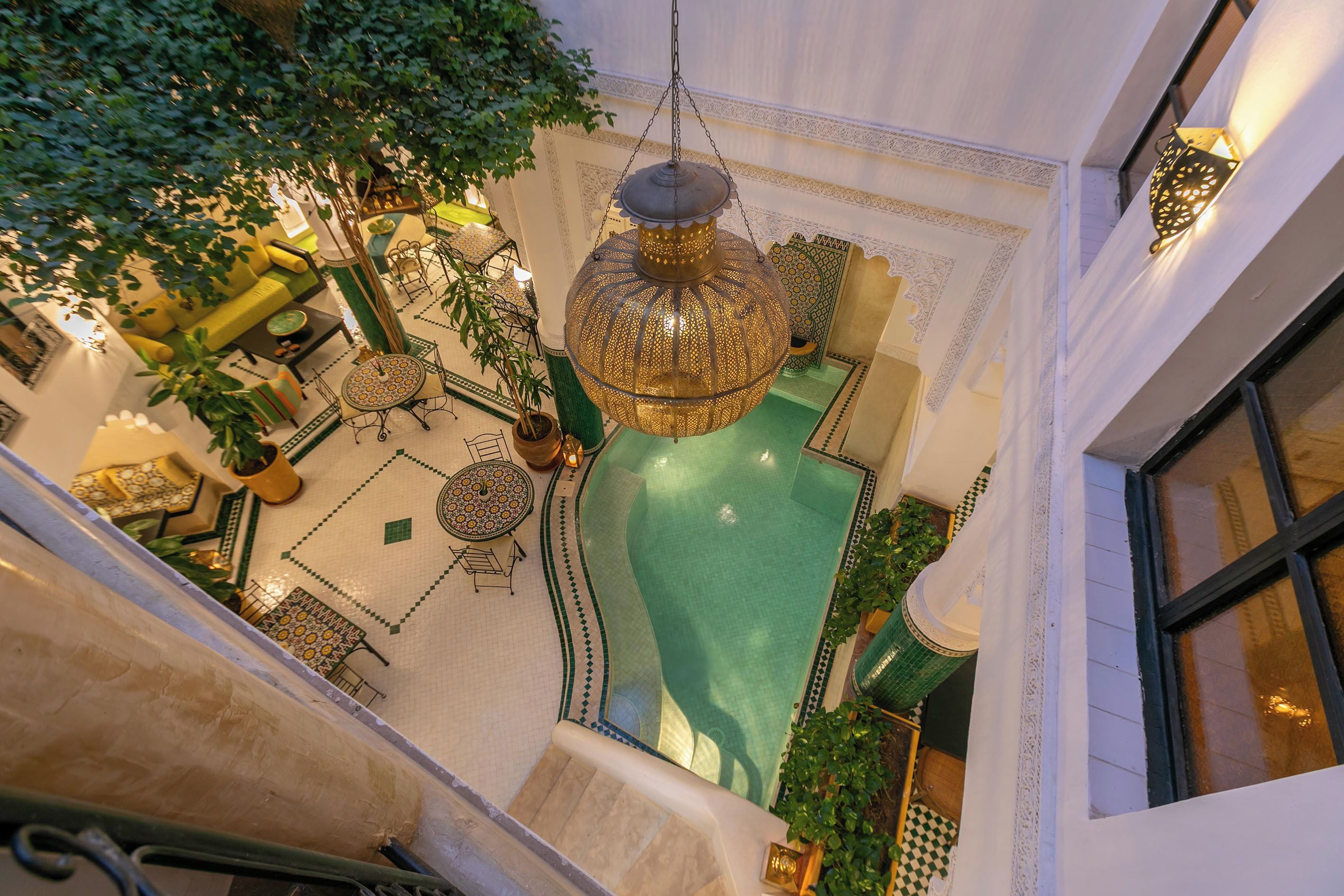 A multi-level interior with a central pool, ornate lighting fixtures, and a staircase.