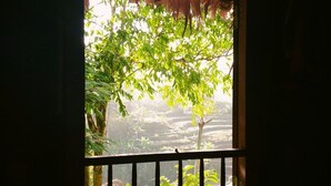A room with a window overlooking a lush garden.