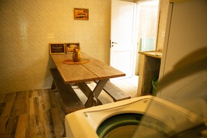 A bathroom with a wooden bench, a toilet, and a framed picture on the wall.
