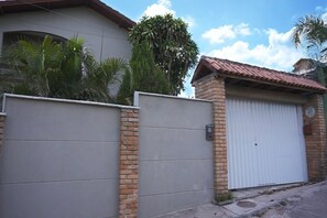 A residential building with a gated entrance, a garage, and a brick wall.