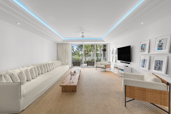 Una sala de estar moderna con un sofá, una mesa de centro y un televisor.