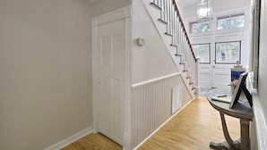 A staircase with white railings and a wooden floor leading to a door with a window.
