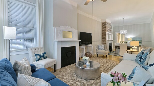 A modern living room with a fireplace, sofa, armchair, and coffee table.