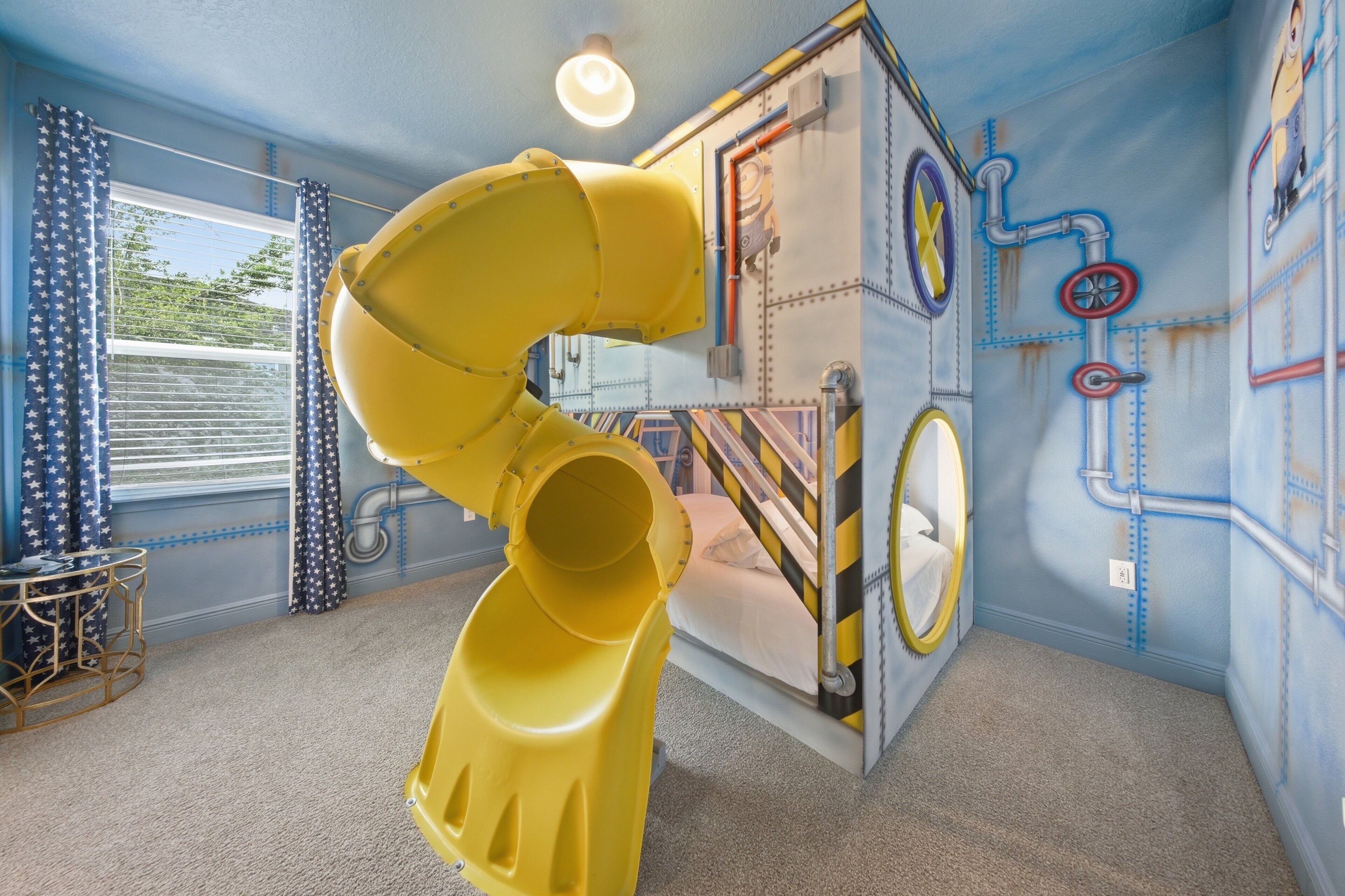Une salle de jeux avec un toboggan, un lit et une fenêtre avec des rideaux.