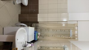 Een moderne badkamer met toilet, wastafel en douchehoek.