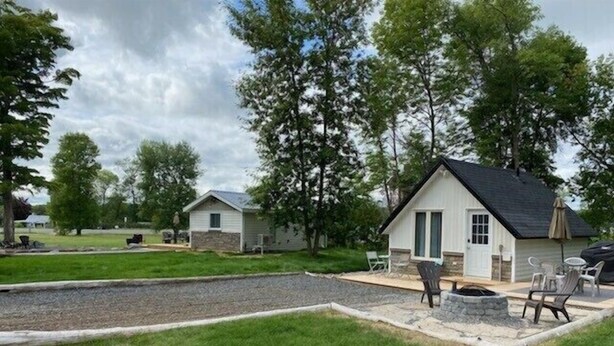 Ein Campingplatz mit zwei Hütten, einer Feuerstelle und Sitzgelegenheiten im Freien.