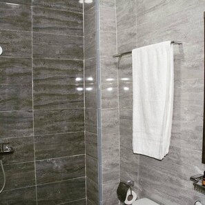 Habitación triple Deluxe | Baño | Ducha y cabezal de ducha tipo lluvia