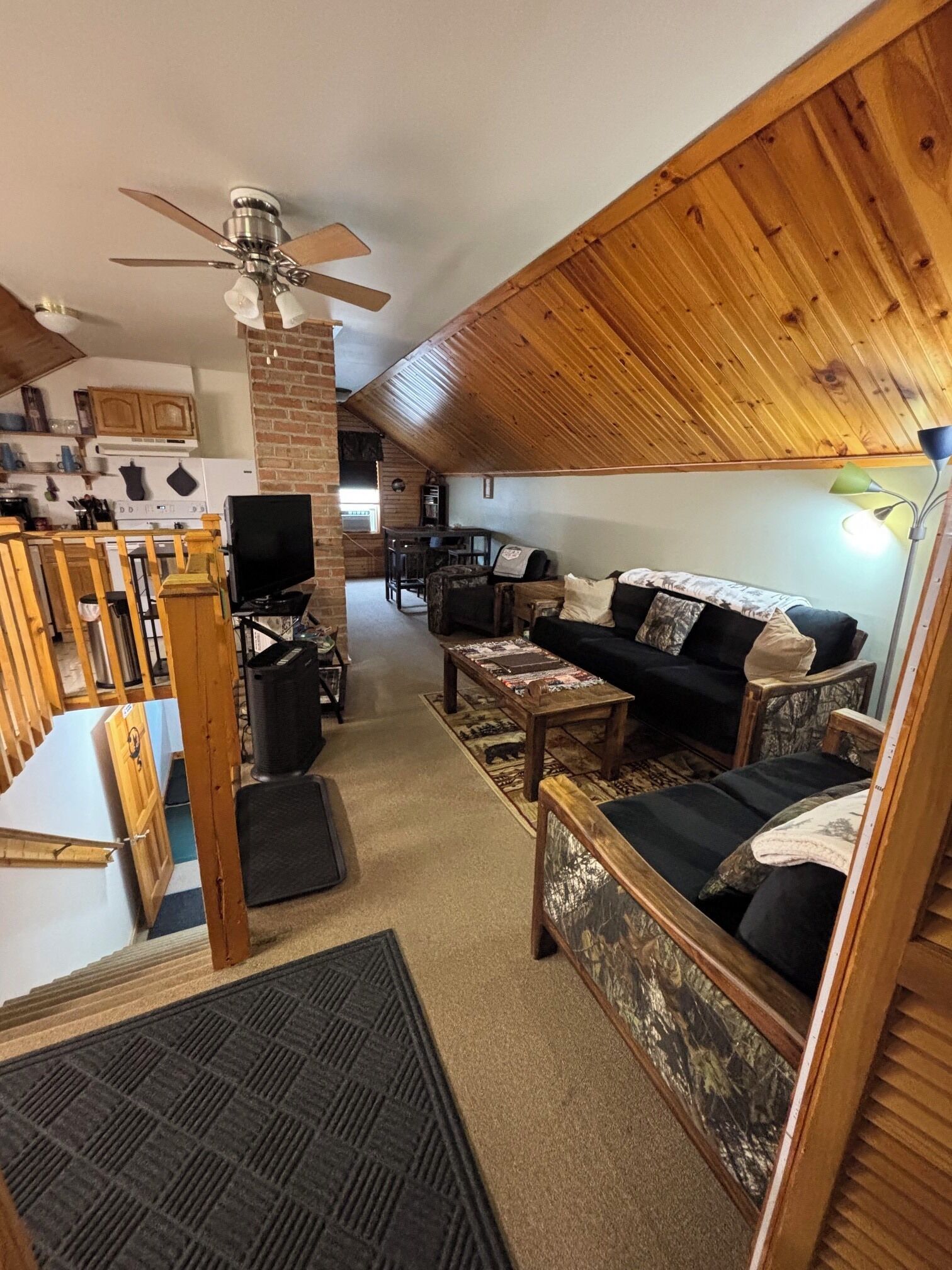 A cozy living room with a fireplace, a television, and a dining area with wooden furniture.