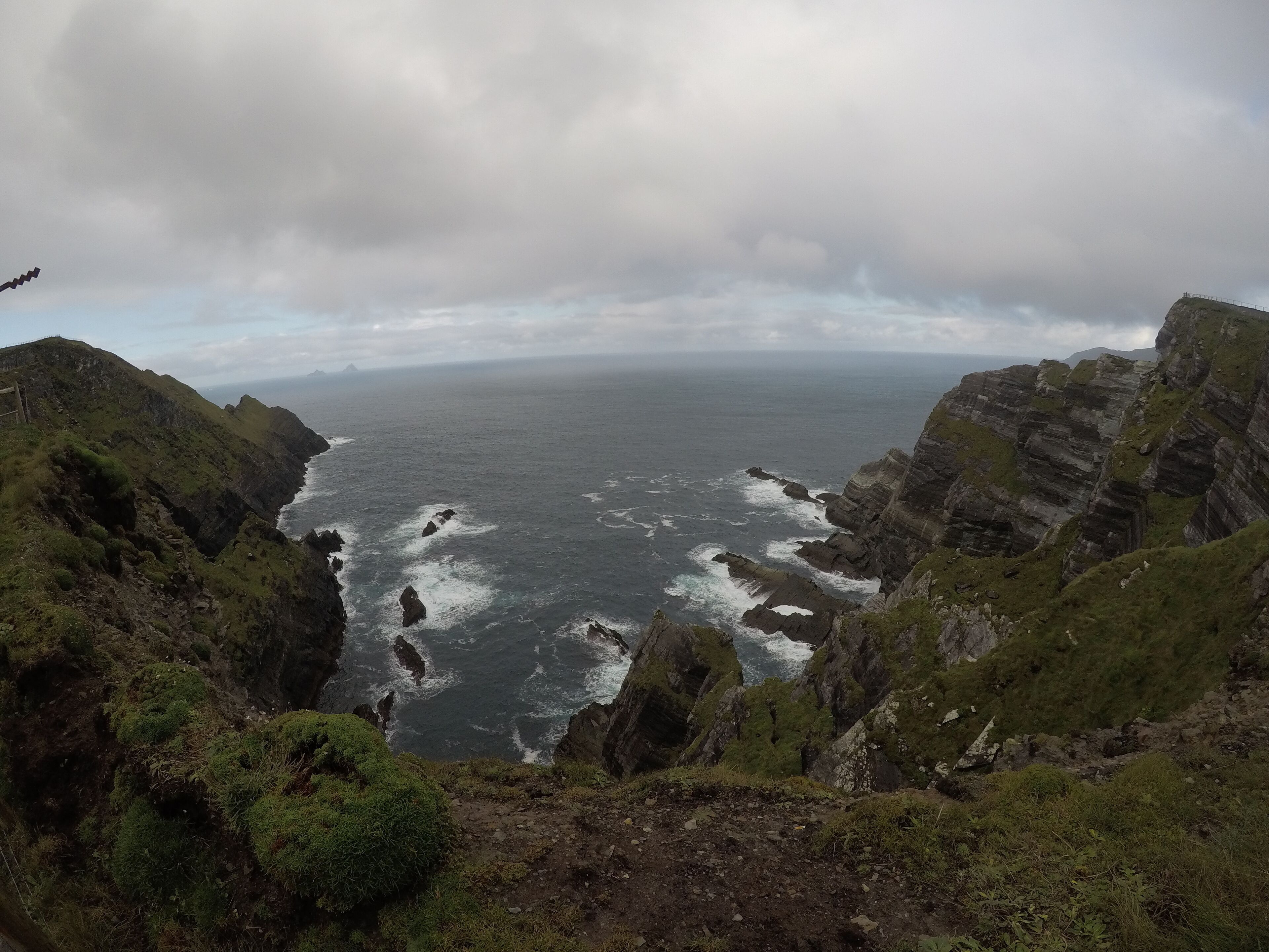 A coastal landscape with rocky cliffs and a view of the sea.