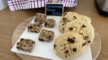 A tray of homemade scones and bars on a wooden table.