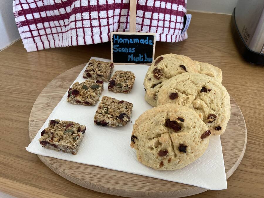 A tray of homemade scones and bars on a wooden table.