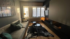 Ein modernes Wohnzimmer mit einer Couch, einem Couchtisch und einem Kamin.
