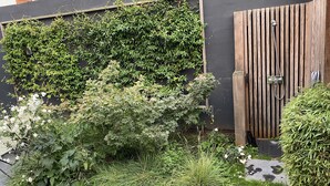 Ein Garten mit verschiedenen Pflanzen und einem Holztor.