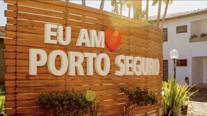 A wooden sign with the text "EU AM PORTO SEGURO" and a heart symbol. - Apartamento - La Corte (Porto Seguro)