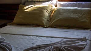 A neatly made bed with white linens and two pillows. - Apartamento - La Corte (Porto Seguro)
