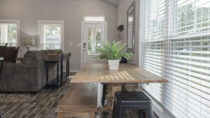 Un espace repas avec une table en bois, des bancs et une plante en pot.