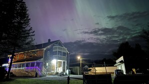 A two-story building with a porch and a visible garage. - Majestic Recreational Lodging w/ Snowmobile and Side x Side rentals on Long Lake (Sinclair)
