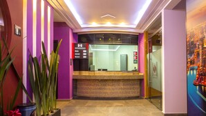 A reception area with a reception desk, a glass partition, and a poster on the wall. - Hotel Zaragoza Inn Boutique (Mexico City)