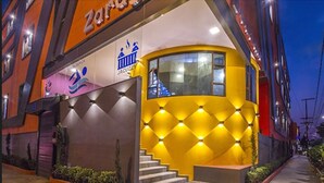A building with a yellow facade, a staircase leading to an entrance, and signage for a 'JACUZ' service. - Hotel Zaragoza Inn Boutique (Mexico City)