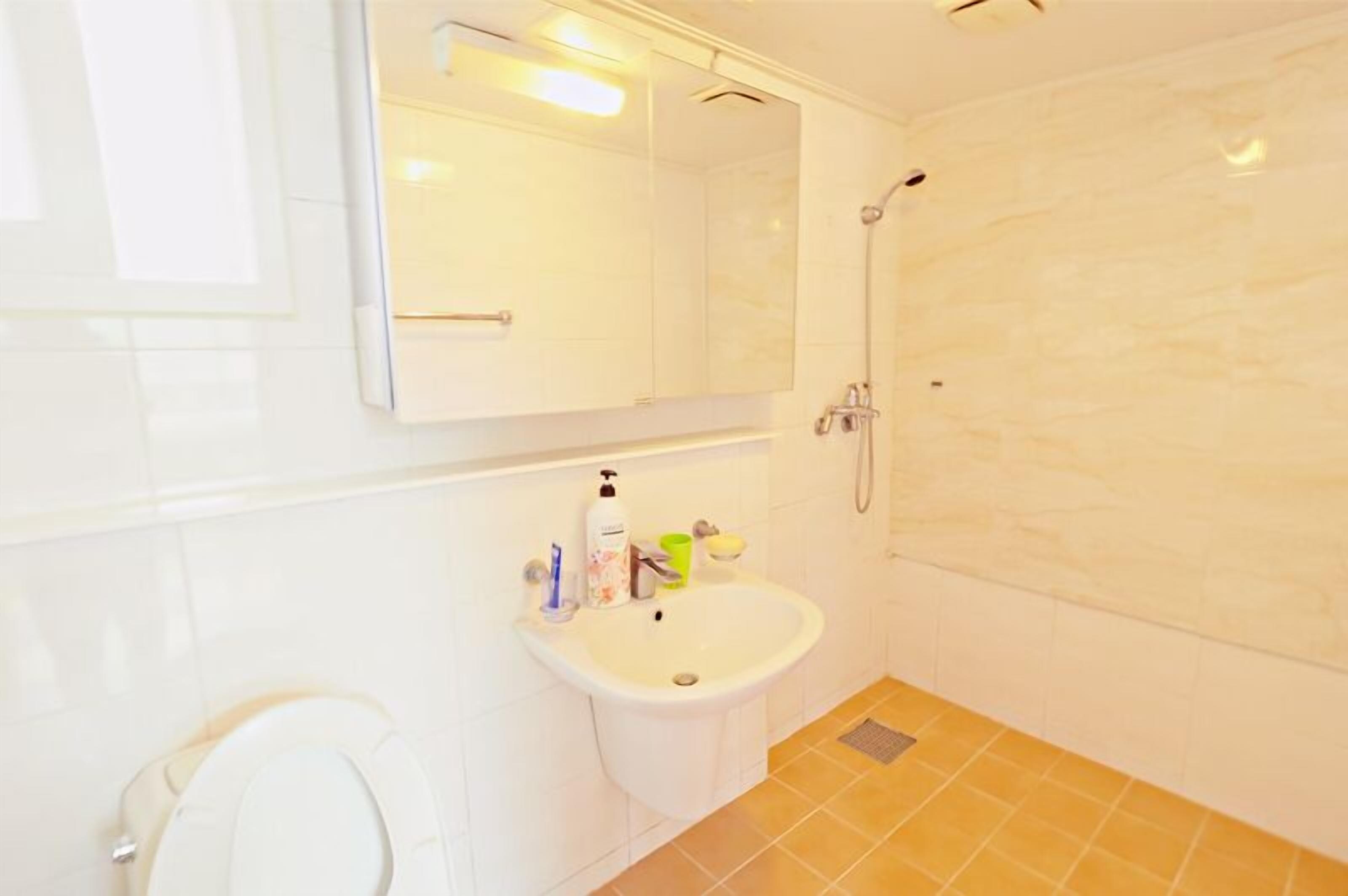 Ein Badezimmer mit Toilette, Waschbecken und Dusche.