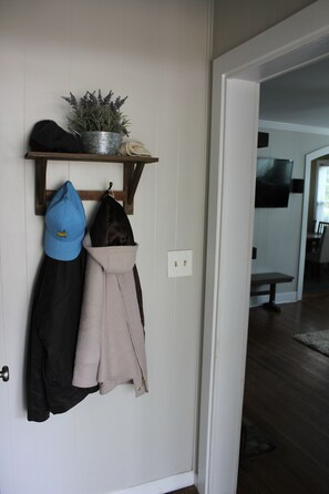 Cozy hallway leading to a room with a TV and a comfortable bench.