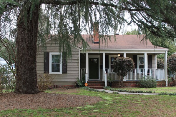 Classic home with a traditional facade, featuring a front porch and a well-manicured lawn.