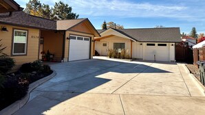 A residential property with a garage, a covered porch, and a driveway. - Home with gated driveway near River & Downtown (Grants Pass)
