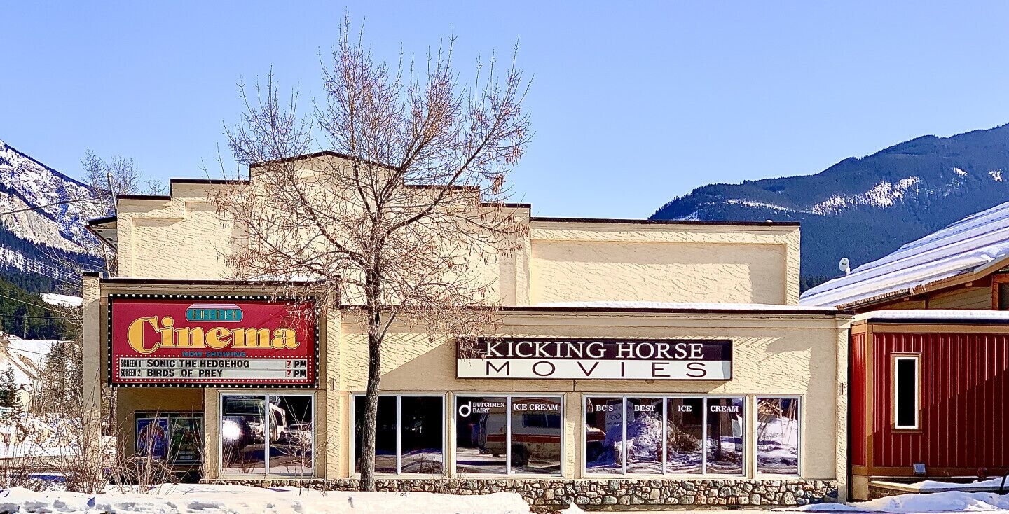 A cinema and a movie theater with a mountainous backdrop.