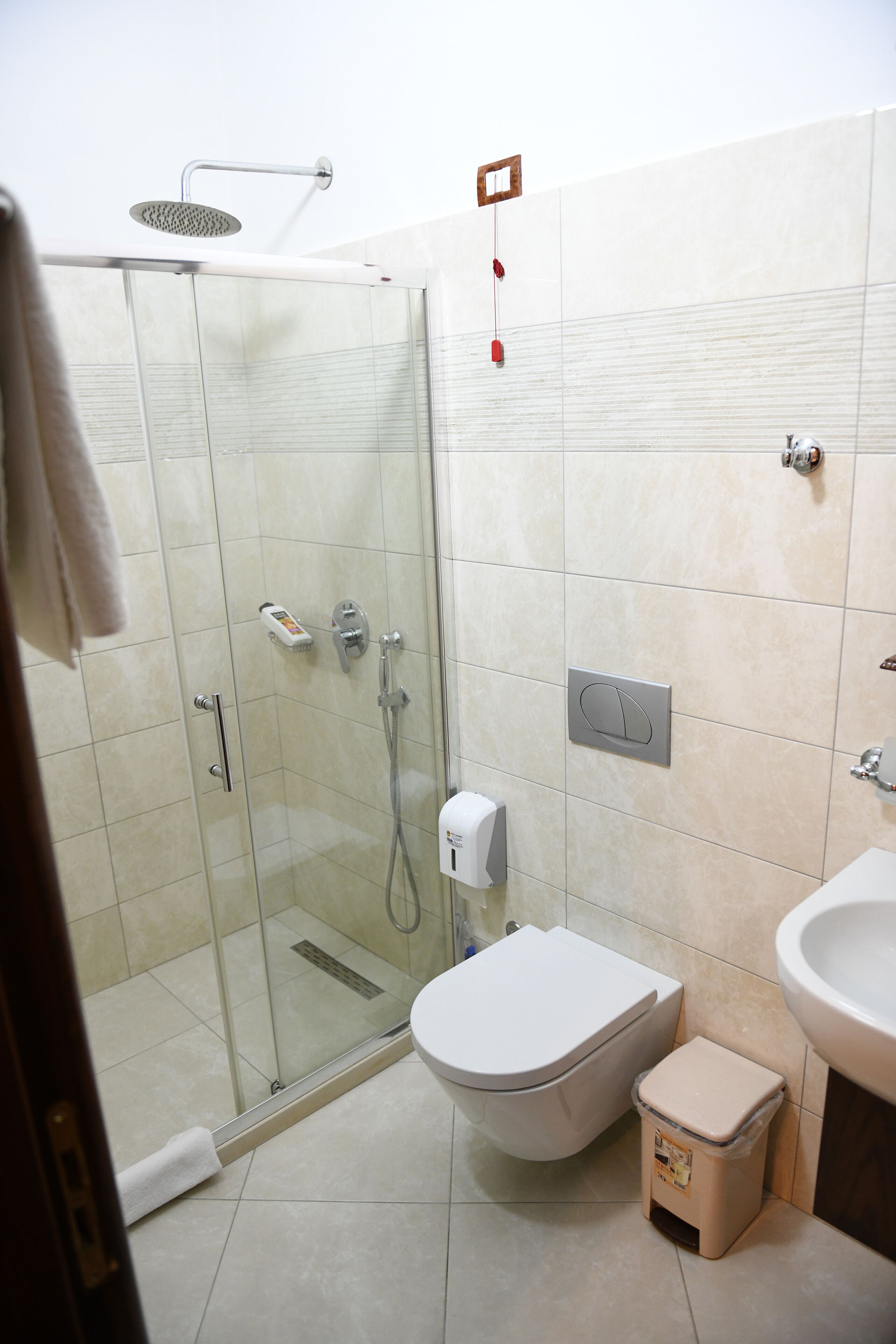 Un baño con ducha de vidrio, inodoro y lavamanos.