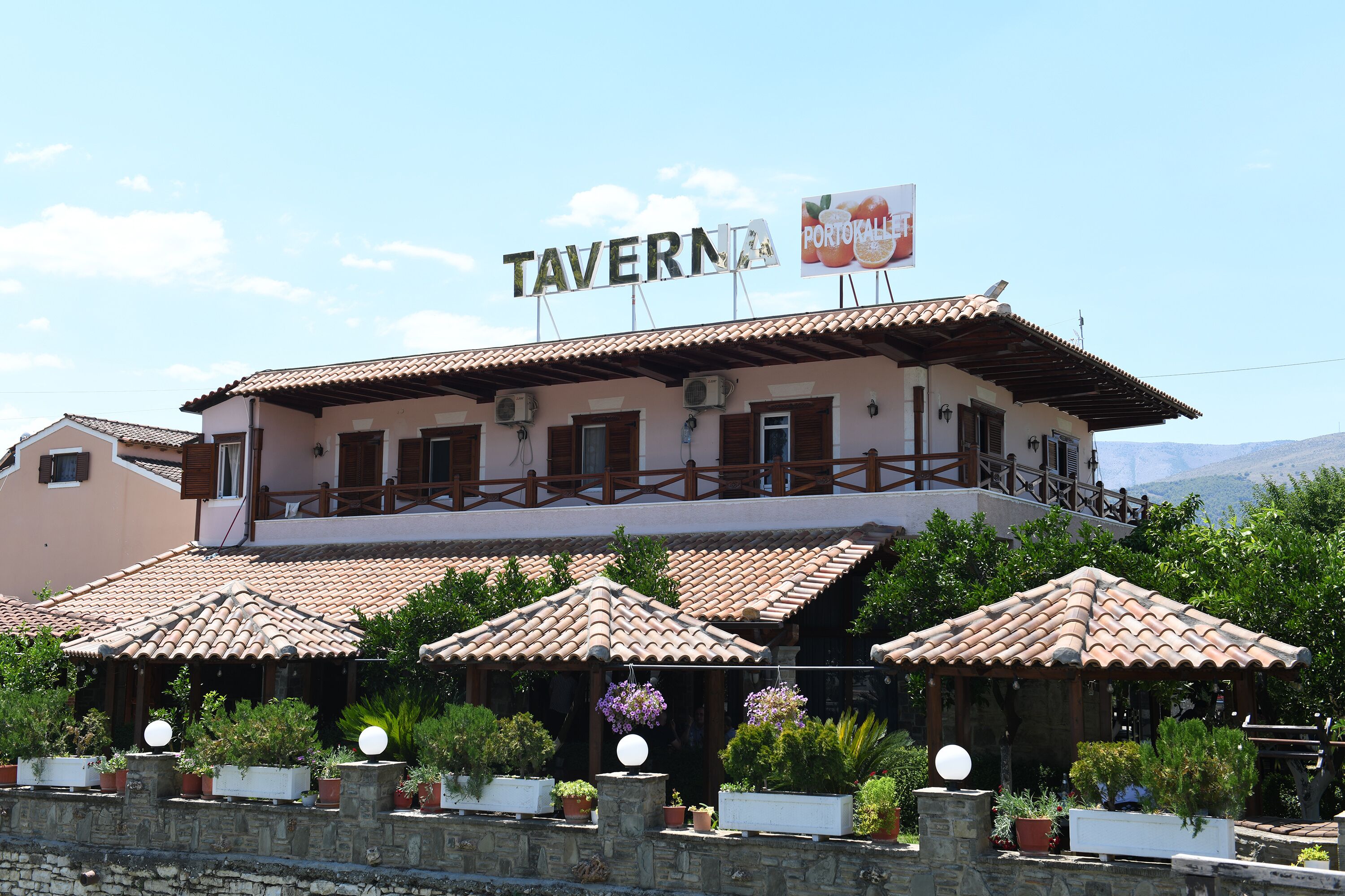 Un edificio de dos pisos con un letrero que dice "TAVERNIA PORTOKALLET".