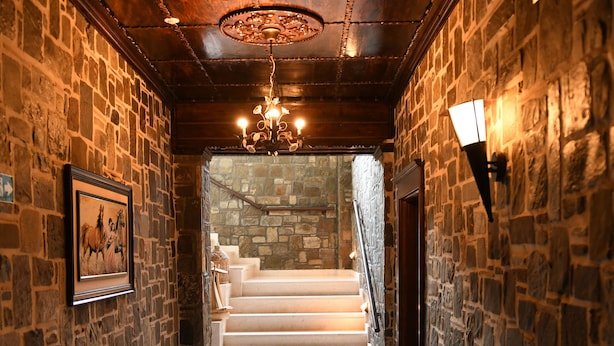 A stone-walled hallway with a marble floor leading to a staircase. - Hotel Kaceli (Berat)