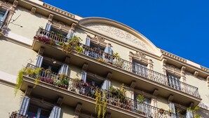 A multi-story building with balconies adorned with plants and flowers. - MODERNIST FAMILY APARTMENT by PriorityVillas (Barcelona)