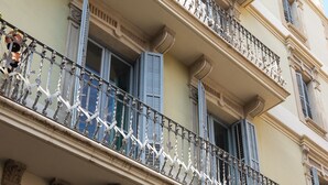 A multi-story building with ornate balconies, large windows with shutters, and classical architectural details. - MODERNIST FAMILY APARTMENT by PriorityVillas (Barcelona)