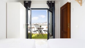 A hotel room with a balcony, a wooden door, and a view of the cityscape. - TEBAR BEACH in Playa Blanca (Playa Blanca)