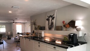 A modern kitchen with a large island, stainless steel appliances, and a minimalist design. - Private Vacation Home w/ Heated Pool. Walk/Bike to Vanderbilt Beach & Amenities. (Naples)
