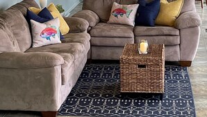 Ein Wohnzimmer mit einem Ecksofa, einem Couchtisch und einem Esstisch.