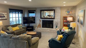 Ein Wohnzimmer mit Kamin, Fernseher und bequemen Sitzgelegenheiten.