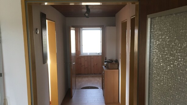 A narrow hallway with wooden flooring leading to a kitchen area. - Large vacation apartment / fitter's apartment on the outskirts of the village in a quiet location (Hochstadt am Main)