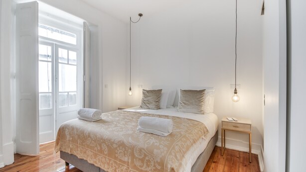 A bedroom with a bed, bedside tables, and a window. - Saldanha Pool & Garden (Lisbon)