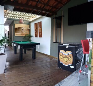 Relax in a stylish space with a pool table, flat-screen TV, and lush greenery.