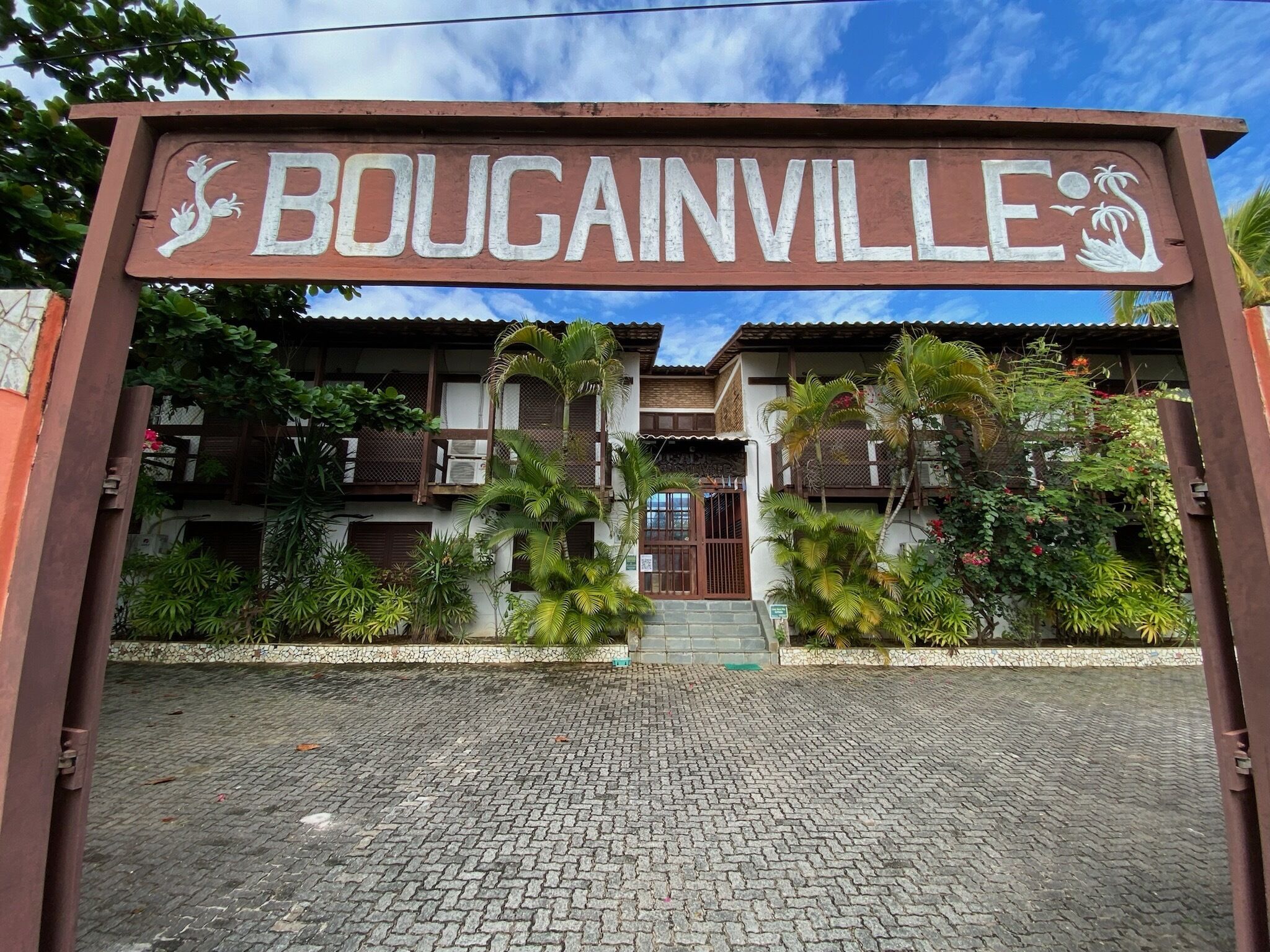 A sign with the name "BOUGAINVILLE" and a logo of a palm tree.
