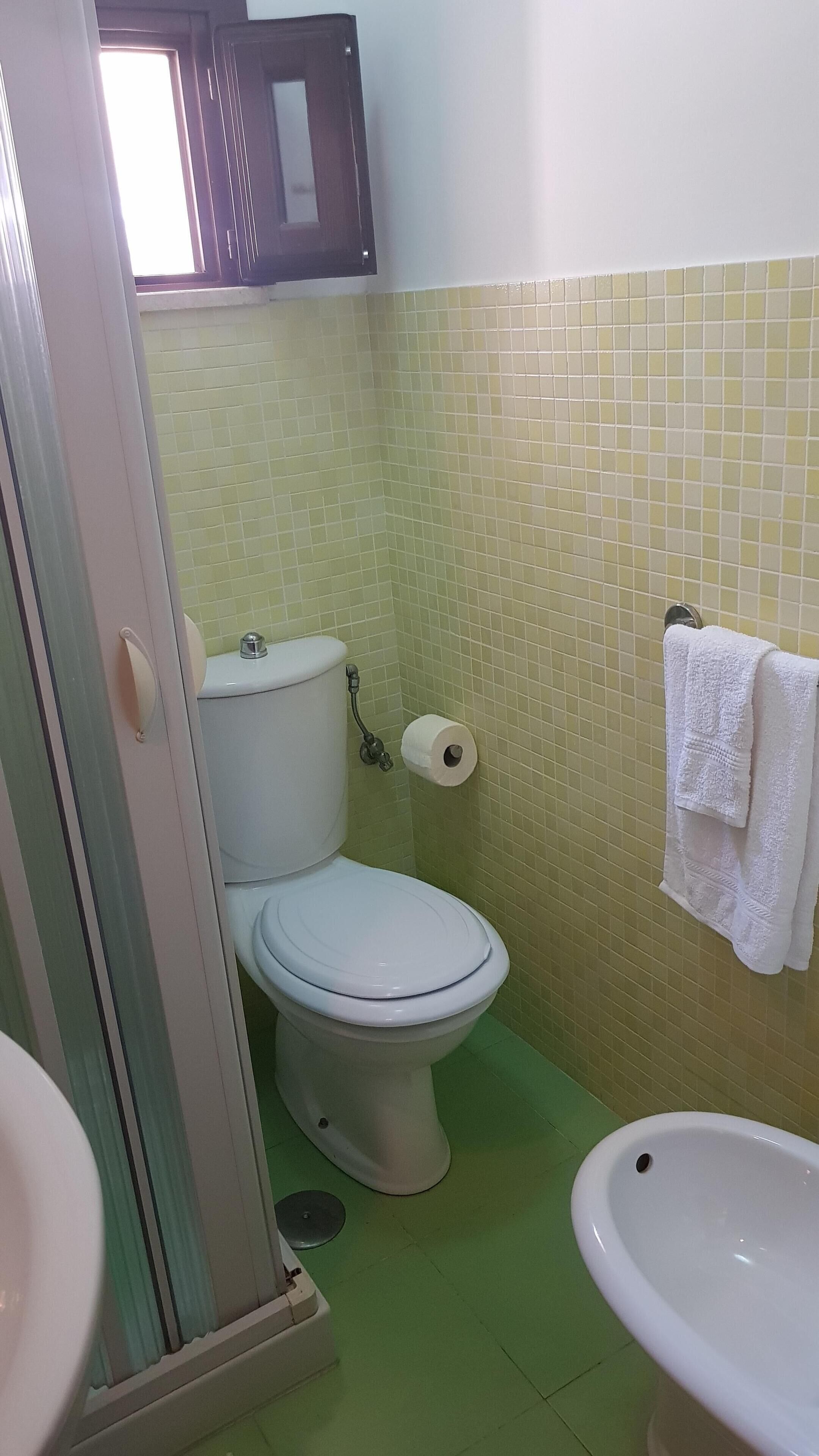 Ein Badezimmer mit Toilette, Waschbecken und Handtuchhalter.