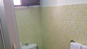 A bathroom with a toilet, a sink, and a towel rack.