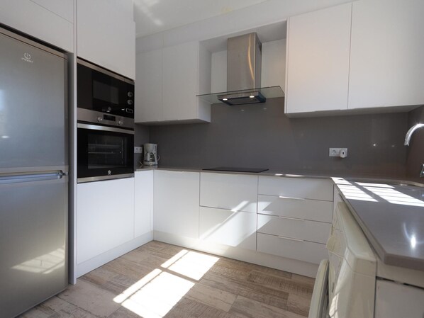 A modern kitchen with stainless steel appliances, white cabinetry, and a built-in oven. - INNOUTHOME FAMILY PRIVATE VILLA WITH SWIMING-POOL, BBQ AND WIFI_ROVELLÓ (L'Ametlla de Mar)