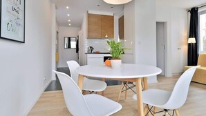 A modern kitchen with wooden cabinets, a white countertop, and a potted plant.
