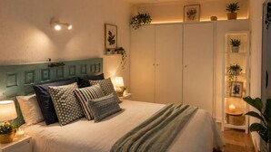 Un dormitorio con cama, mesitas de noche, ventilador de techo y armario.
