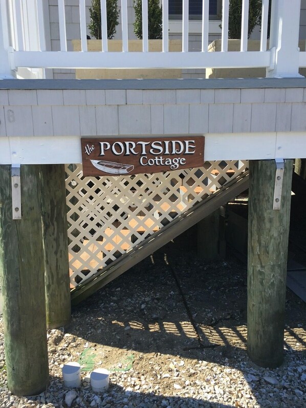 A wooden deck with a sign reading "The Portside Cottage."