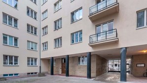 Un edificio de varios pisos con fachada color beige, múltiples ventanas y balcones.